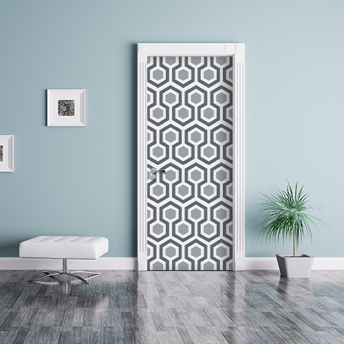 Séjour avec une porte décorée d'un sticker nid d'abeille avec motif hexagones gris.