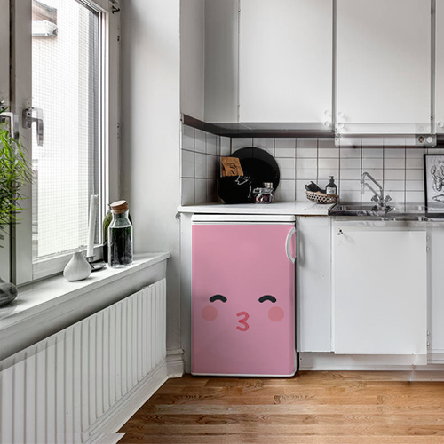 Cuisine moderne avec un sticker décoratif smiley bisou rose collé sur le petit frigo