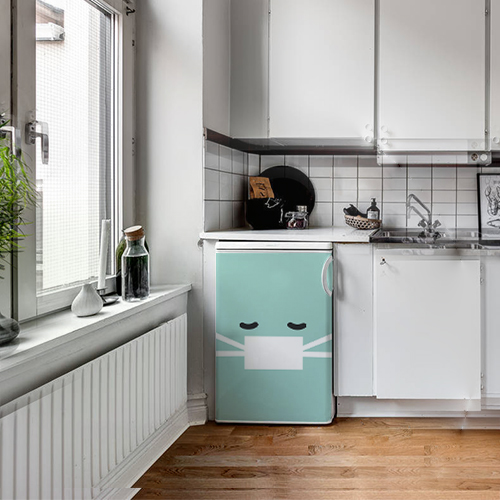 Cuisine moderne blanche et noire avec un sticker smiley malade turquoise collé sur le frigo