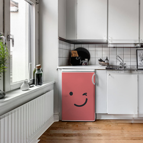 Cuisine standard avec un sticker clin d'oeil rouge collé sur le lave vaisselle